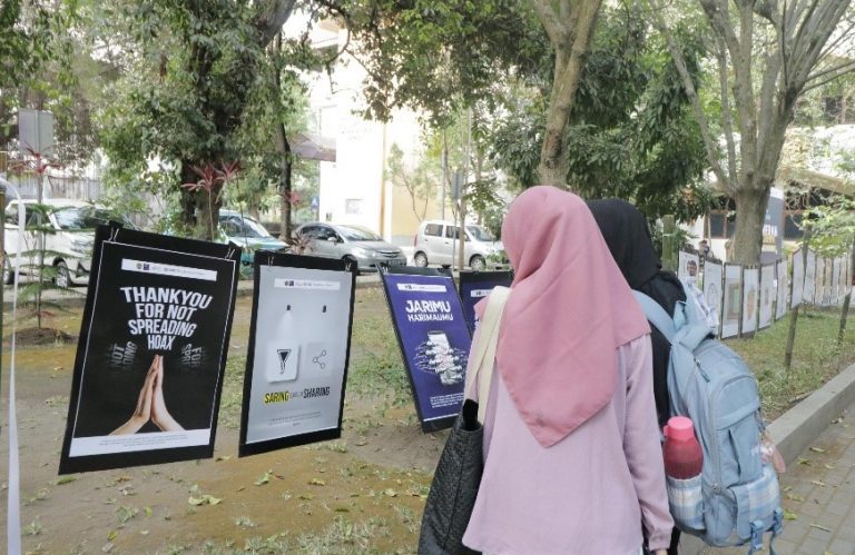 Gambar - Mahasiswa Fishum melihat deretan karya berupa poster yang memiliki makna ajakan dan edukasi anti hoax